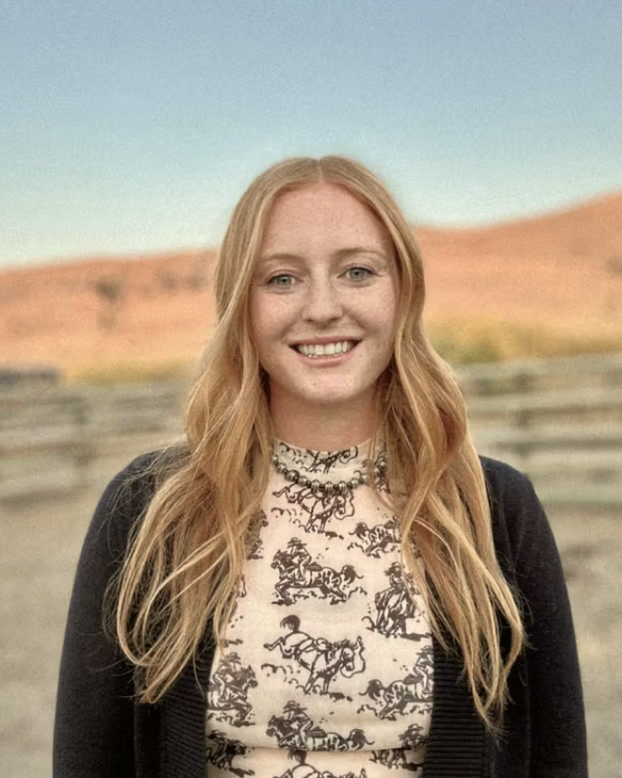 Haley, Ambrook Customer Success team member, smiling in a Montana field at golden hour