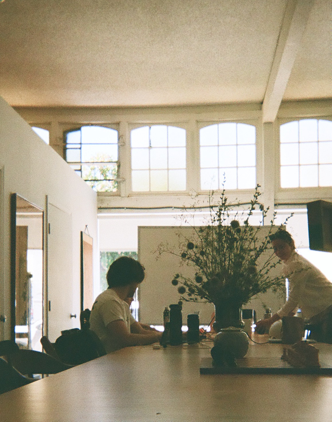 Ambrook's San Francisco office: two people working at a long table beneath tall arched windows