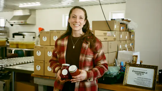 Kimberly, a food processing business owner, standing in her warehouse — 100% increase in sales